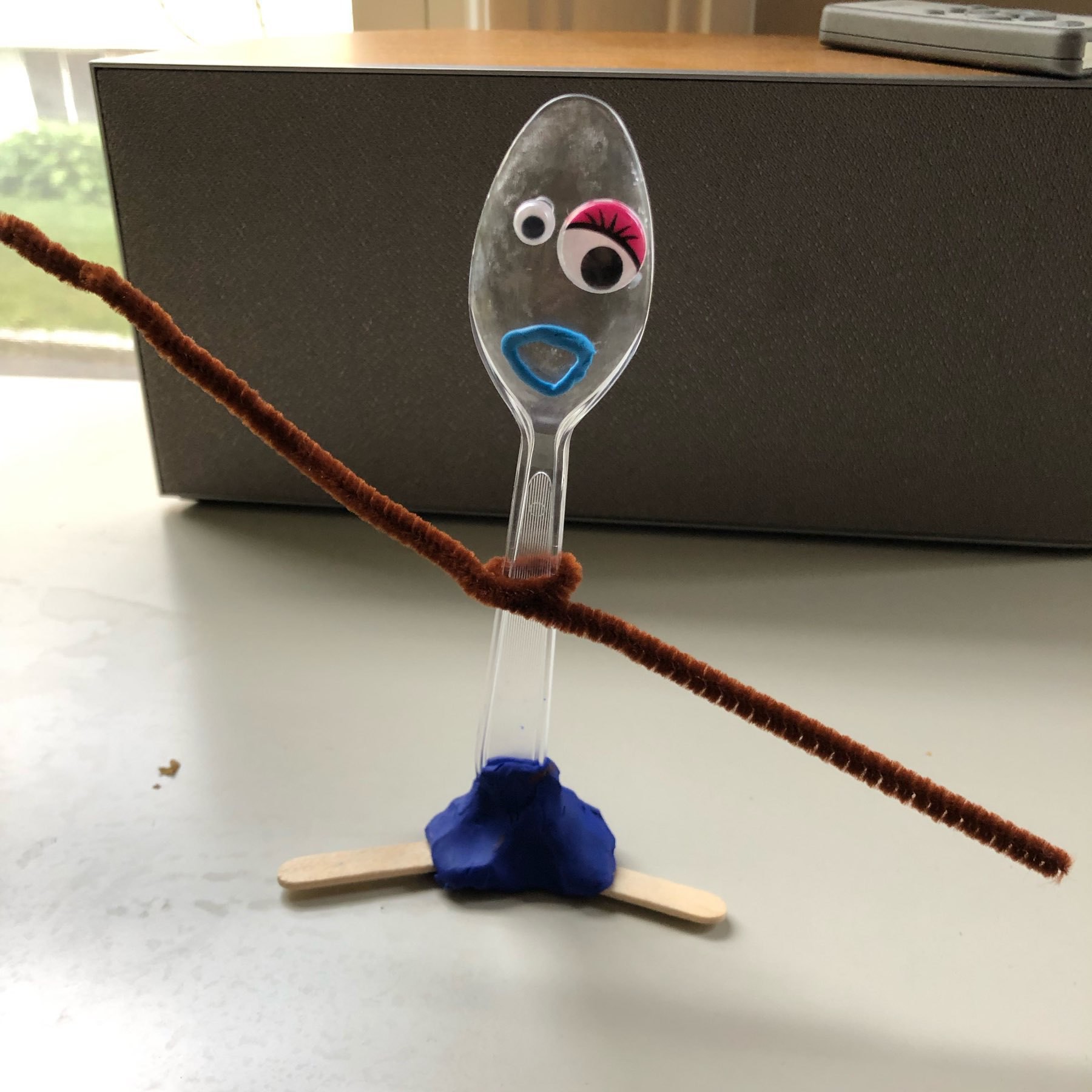 Makeshift toy made from a plastic spoon, pipe cleaner, clay, and popsicle stick. Inspired by Toy Story 4.