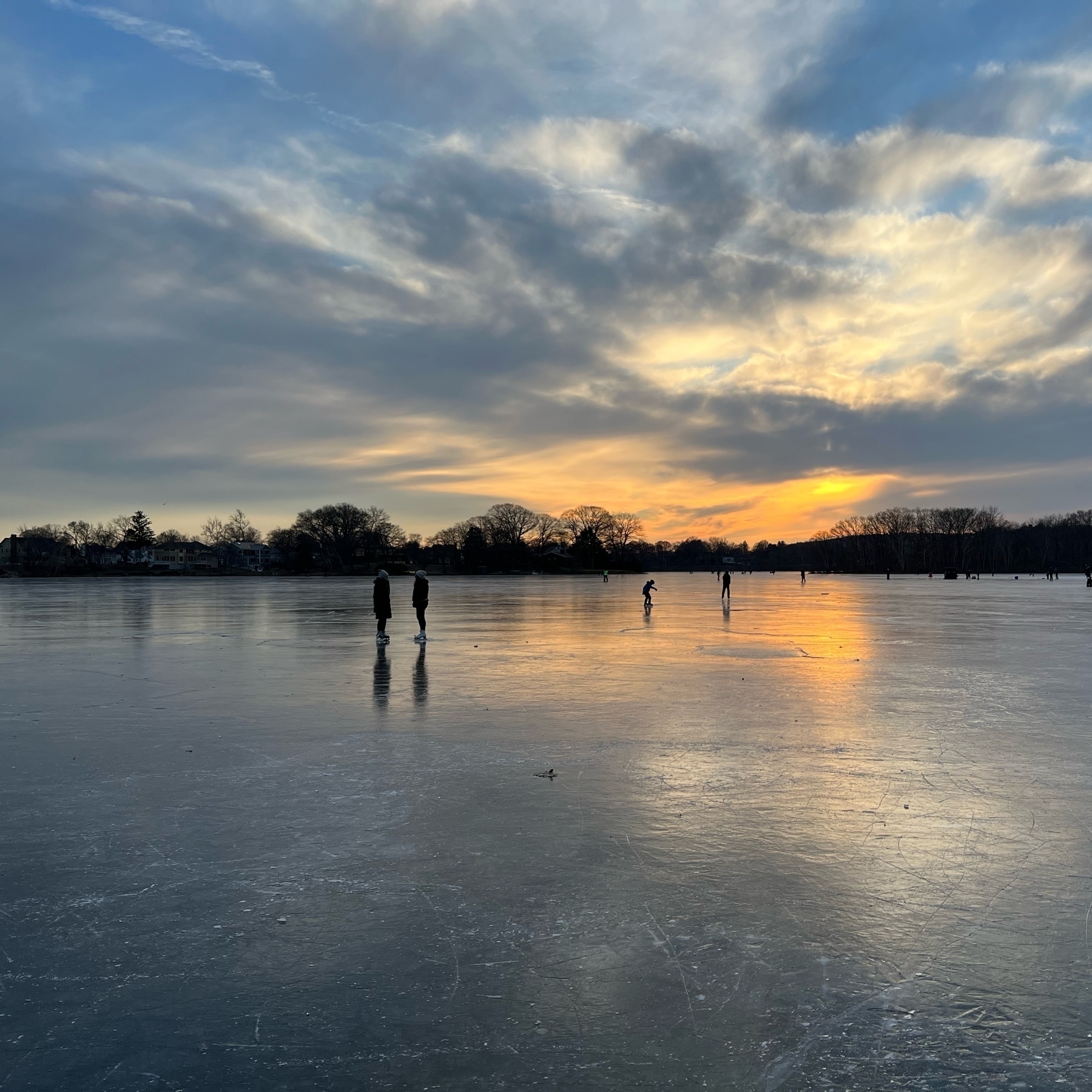 picture of a frozen lake with sunset skies behind it