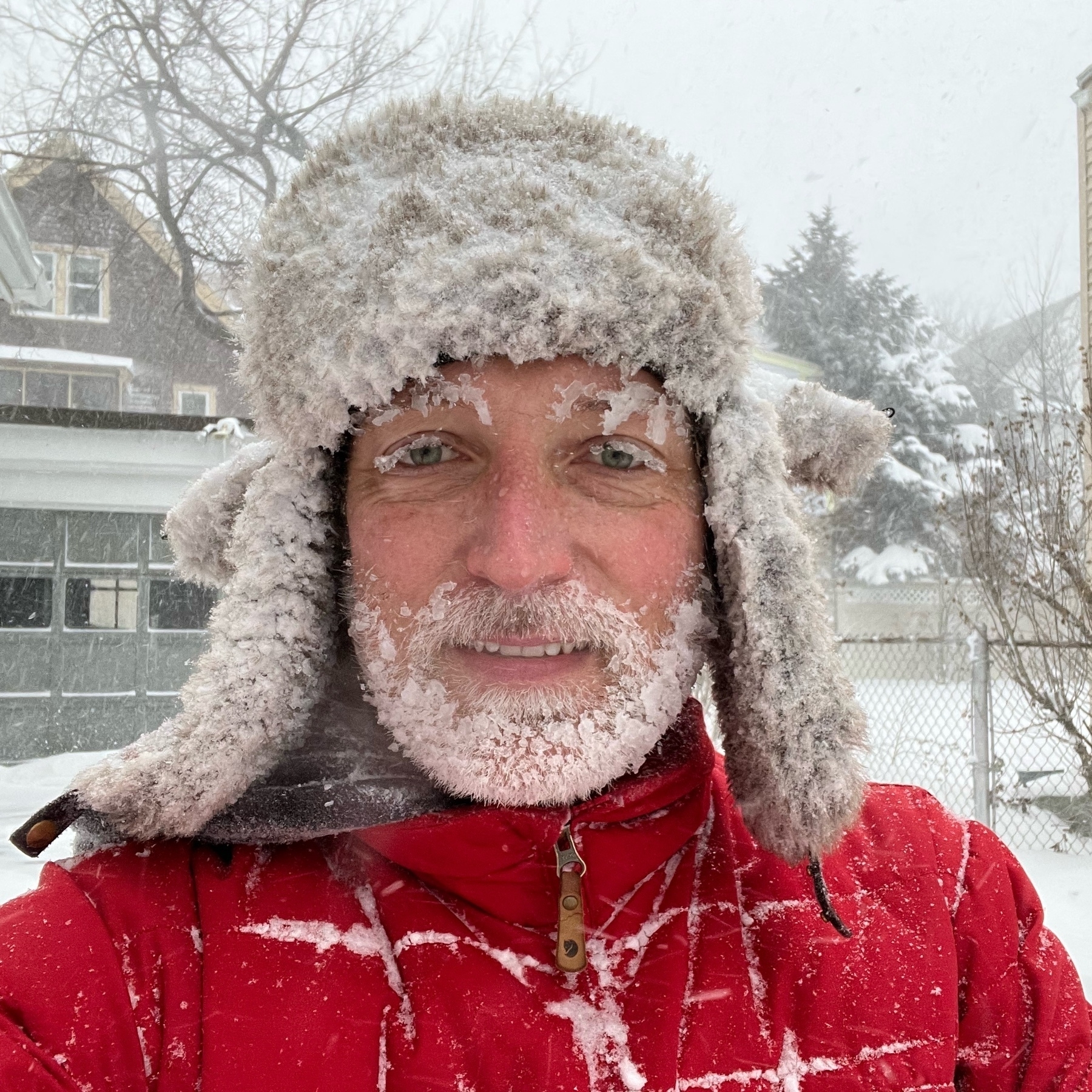 selfie in snowy outdoors with snow covered cap and snow and ice stuck to beard and eyelashes