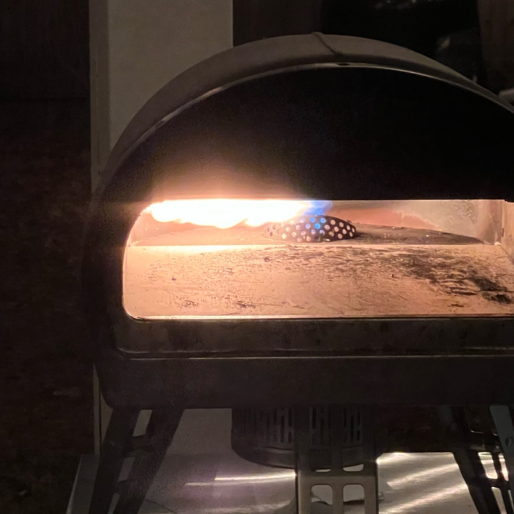 roccbox pizza oven with windswept flame against a dark night backdrop